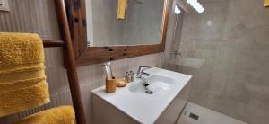 a bathroom with a white sink and a mirror at Casilla de Costa Luz Home con Terrazza Fronte Piscina in La Oliva +14 photos