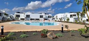 a swimming pool in front of a building at Casilla de Costa Luz Home con Terrazza Fronte Piscina in La Oliva