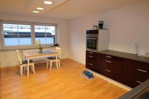 a kitchen and dining room with a table and a refrigerator at HSH Apartments in Pressath