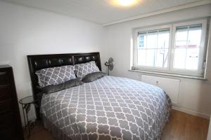 a bedroom with a large bed and two windows at HSH Apartments in Pressath