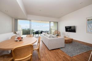 a living room with a table and a couch at Groves Sunset Views in Aspendale in Aspendale