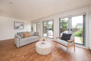 a living room with a couch and a chair at Groves Sunset Views in Aspendale in Aspendale
