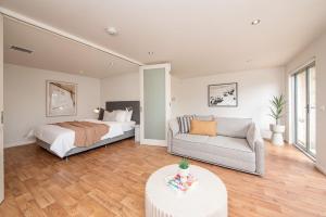 a bedroom with a bed and a couch at Groves Sunset Views in Aspendale in Aspendale