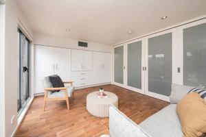 a living room with a couch and a table at Groves Sunset Views in Aspendale in Aspendale