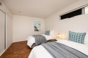 a bedroom with two beds and a tv on the wall at Groves Sunset Views in Aspendale in Aspendale