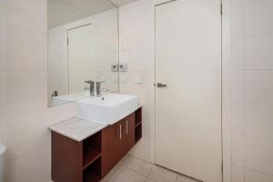 a bathroom with a sink and a mirror at Groves Sunset Views in Aspendale in Aspendale