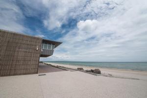 a building on the beach next to the ocean at Groves Sunset Views in Aspendale in Aspendale