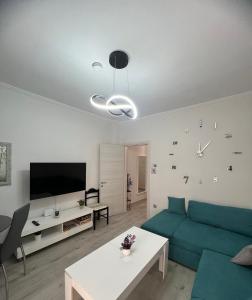 a living room with a blue couch and a tv at Serres city center modern apartment (Monika) in Serres