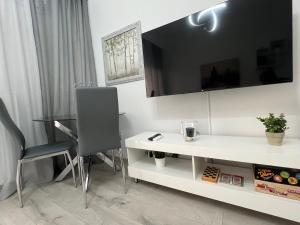 a room with a white desk and a tv on the wall at Serres city center modern apartment (Monika) in Serres