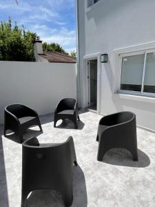 tres sillas negras sentadas en un patio junto a un edificio en Dolores City en 