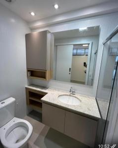 uma casa de banho com um WC, um lavatório e um espelho. em Studio no Red Design em Vitória