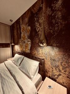Un dormitorio con una cama y una pared con flores. en Kathy's Elegance, en Buşteni