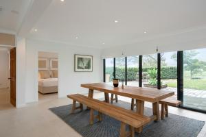 a dining room with a wooden table and benches at Bonvilla Estate in Pokolbin