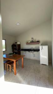 a kitchen with a wooden table and a refrigerator at Chalé da Picareta in São Roque de Minas