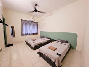 una camera con 2 letti e un ventilatore a soffitto di Air-home M3 Simpang near Aulong Econsave, 4BR, 10pax, Netflix a Taiping