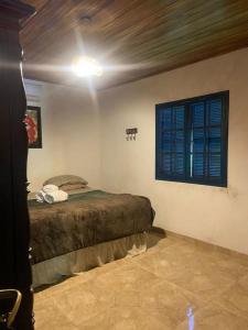 um quarto com uma cama e uma janela em Hotel Fazenda Bela Riba em Barrinha