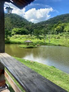 a view of a lake with an umbrella in the middle at Hotel Fazenda Bela Riba in Barrinha