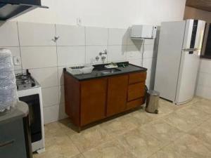a kitchen with a sink and a refrigerator at Hotel Fazenda Bela Riba in Barrinha