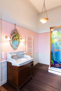 a bathroom with a sink and a painting on the wall at Hotel-Musée Villa Bagatelle in Irigny