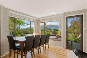 une salle à manger avec une table, des chaises et une grande fenêtre dans l'établissement Mountain View Lodge, à Queenstown