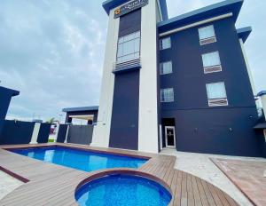 a building with a swimming pool in front of a building at La Quinta by Wyndham Reynosa in Reynosa