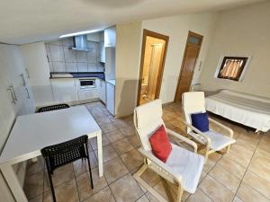 a room with a table and chairs and a bed at Hostal JP y Apartamentos in Sangüesa