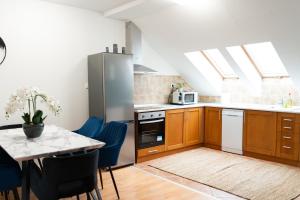 a kitchen with wooden cabinets and a table with blue chairs at Balcony Dohany Street Apartment in Budapest