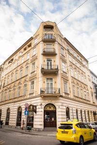 a yellow car parked in front of a large building at Balcony Dohany Street Apartment in Budapest