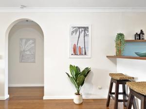 uma sala de estar com paredes brancas e um vaso de plantas em Hawaiian Gardens 17 em Coffs Harbour