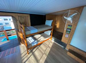 a room with two bunk beds and a fan at Casa do Rogério Hostel in Caxias do Sul
