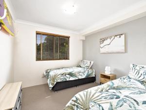 um quarto com 2 camas e uma janela em Hawaiian Gardens 17 em Coffs Harbour