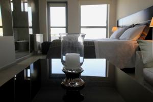 a candle in a glass vase on a table in a room at SAMARÁN SUITES in Villa María