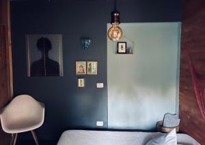 1 dormitorio con pared azul, cama y silla en Casa de Campo - Hotel Desayuno Pizza Bar en Medellín