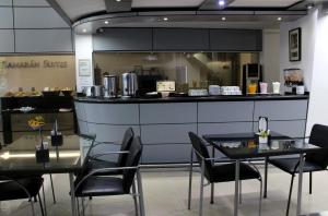 un restaurante con 2 mesas y sillas y una barra en SAMARÁN SUITES, en Villa María