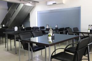 Una sala con mesas y sillas y una pantalla grande. en SAMARÁN SUITES, en Villa María