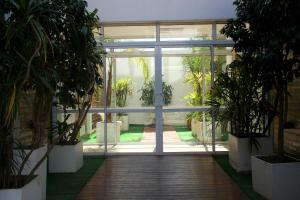 an indoor greenhouse with potted plants and a glass door at SAMARÁN SUITES in Villa María