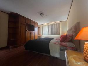 1 dormitorio con 1 cama y escritorio con lámpara en CASA NUEVA, CON DECORACIONES Y ACABADOS NUEVOS SOLO PARA FAMILIAS., en Cuenca