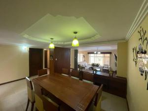 a dining room and living room with a wooden table at CASA NUEVA, CON DECORACIONES Y ACABADOS NUEVOS SOLO PARA FAMILIAS. in Cuenca