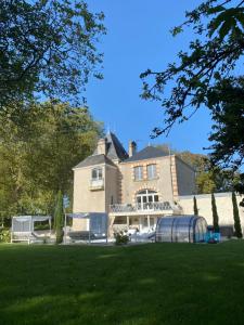 uma casa grande com um relvado verde em frente em Château du Beugnon em La Fosse-de-Tigné