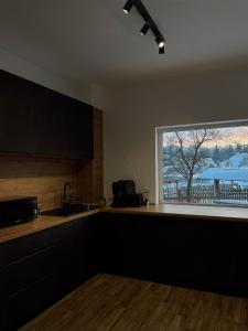 a kitchen with a sink and a window with a view at Private Chalet in Moieciu de Jos