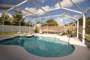 a swimming pool with a boat in the water at Luxurious Pool Cottage Sleep 2 in Carlton