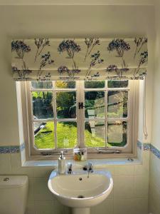 baño con lavabo y ventana en Denham Mount, en Buckinghamshire