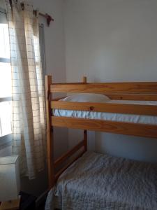 une chambre avec un lit superposé et une fenêtre dans l'établissement Lo de mirella, à La Paloma