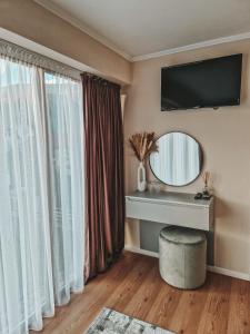 - un salon avec un miroir et une table avec un tabouret dans l'établissement Private Chalet, à Moieciu de Jos