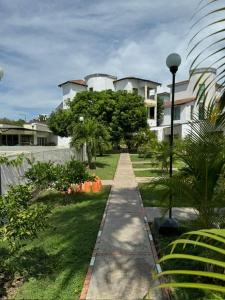 a walk way in front of a house with trees at Hotel TACALOA INN EXPERIENCE in Ricaurte