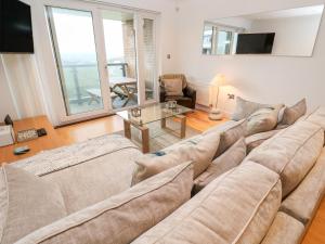 a living room with a large couch and a table at 9 Headland Point in Newquay
