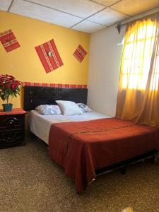 twee bedden in een kamer met vlaggen aan de muur bij Esperanza Hostel in Antigua Guatemala