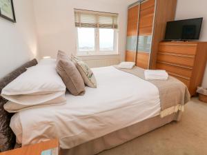 a bedroom with a large bed and a flat screen tv at 9 Headland Point in Newquay