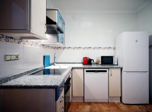 Cozy apartment near the center, Torres de Serrano في فالنسيا: مطبخ مع ادوات بيضاء وثلاجة بيضاء