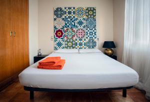Cozy apartment near the center, Torres de Serrano في فالنسيا: غرفة نوم مع سرير وفوط برتقال عليه